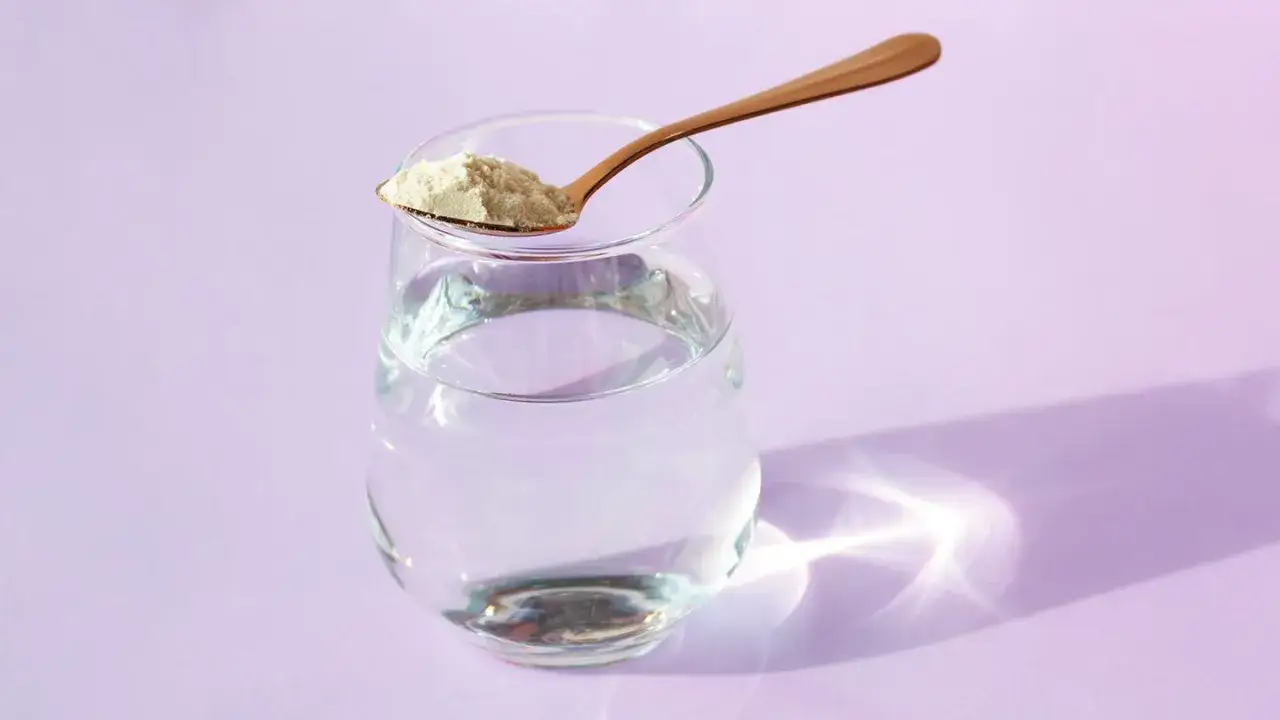 Ein L&ouml;ffel Kollagenpulver liegt auf einem Glas Wasser. Die Frage, darf man Kollagen dauerhaft einnehmen, besch&auml;ftigt viele.