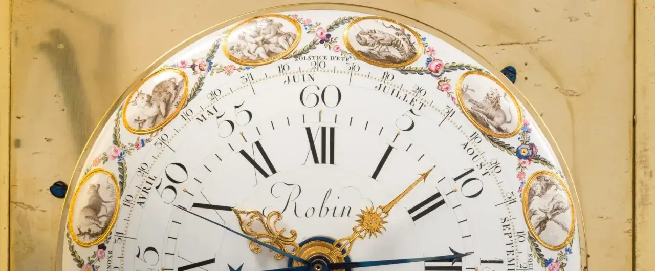Cadran d'une horloge ancienne orné de putti et de signes du zodiaque, avec le nom