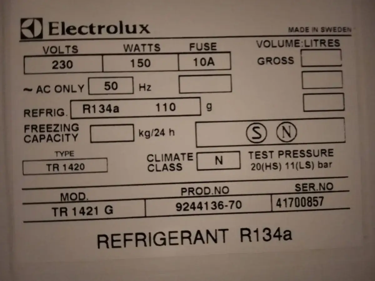 Etykieta Electrolux z danymi technicznymi: 230V, 150W, 10A, 50Hz, R134a (freon), 110g. Model TR 1421 G.