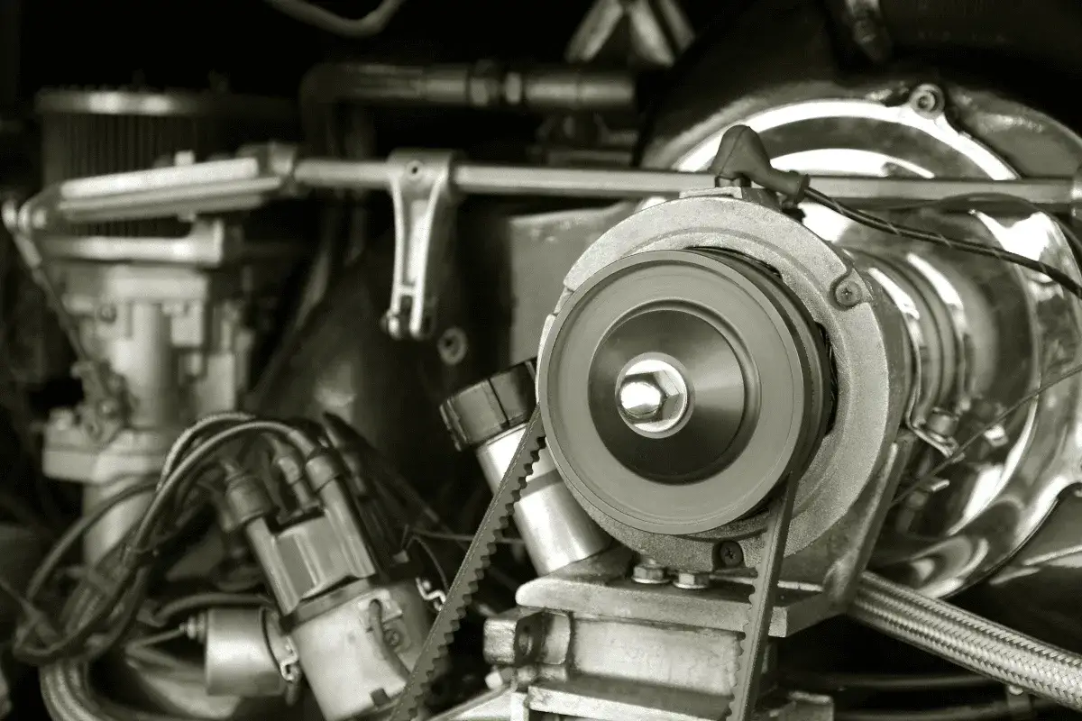 Nahaufnahme eines Motors, bei dem ein **Keilriemen gerissen** ist. Man sieht die Riemenscheibe und Teile des Motors.