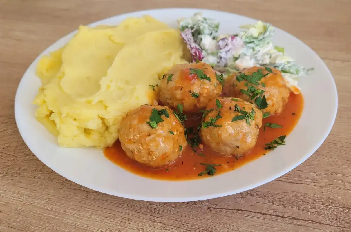 Pyszne pulpeciki w sosie pomidorowym, podane z purée ziemniaczanym i surówką. Idealny obiad!