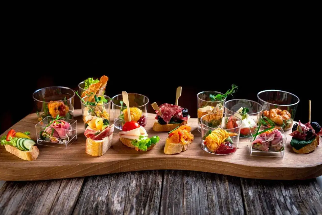 Eleganckie przekąski na desce, idealne na catering imprezowy menu. Różnorodne smaki i kolory zachęcają do degustacji.