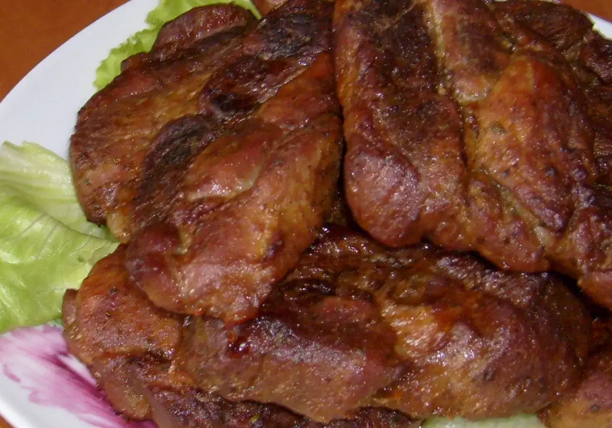 Soczysta karkówka z piekarnika, idealna po marynacie. Podana na liściach sałaty.