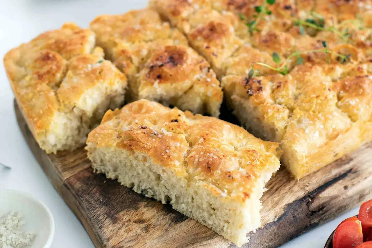 Goldbraune Focaccia, frisch aus dem Ofen, nach einem original Focaccia Rezept. Mit Meersalz bestreut und mit Thymian garniert.