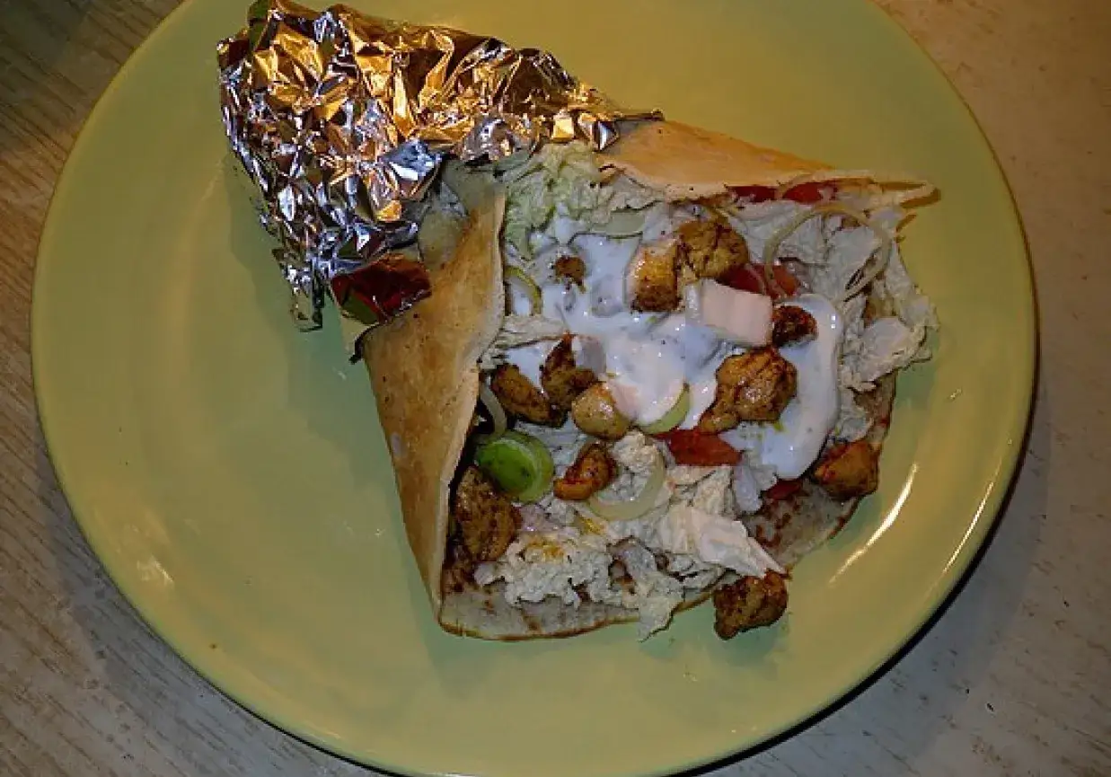 Pyszny kebab z kurczakiem, warzywami i sosem na talerzu. Idealny na szybki obiad, a ten kebab przepis jest prosty do zrobienia w domu!