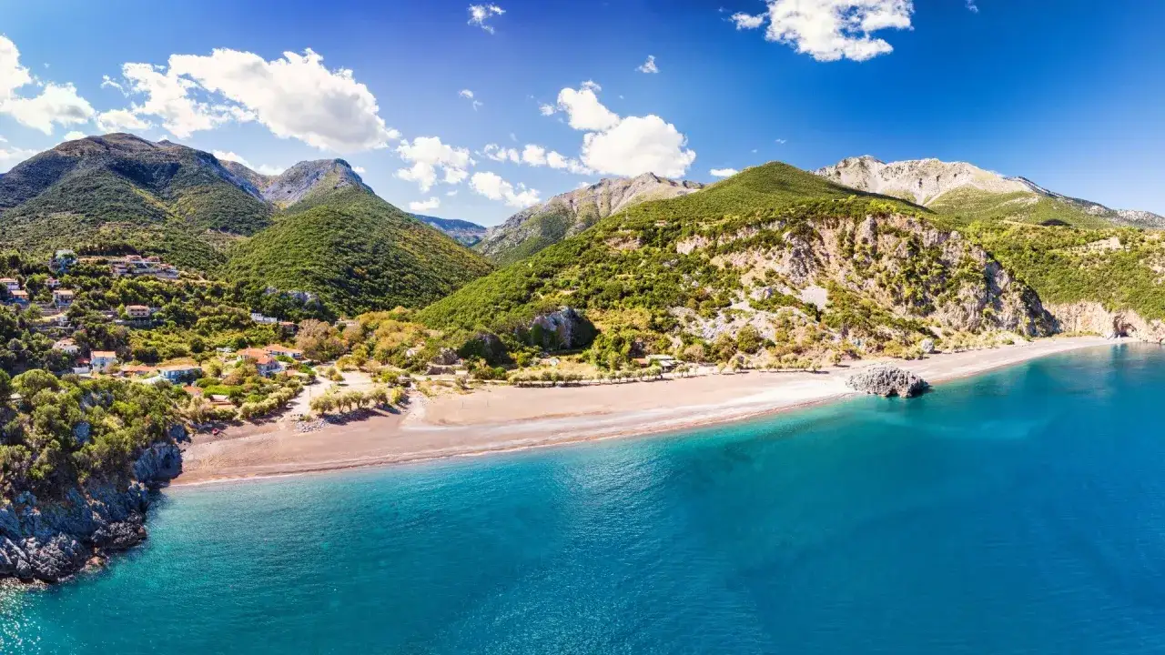 Malownicza zatoka z piaszczystą plażą i zielonymi wzgórzami. Idealne miejsce na **Evia wycieczki fakultatywne**.