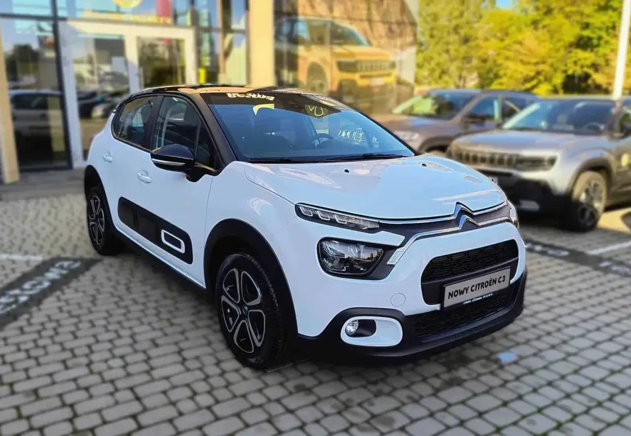 Biały Citroen C3 z czarnym dachem, zaparkowany przed salonem. Sprawdź atrakcyjną cenę tego modelu!