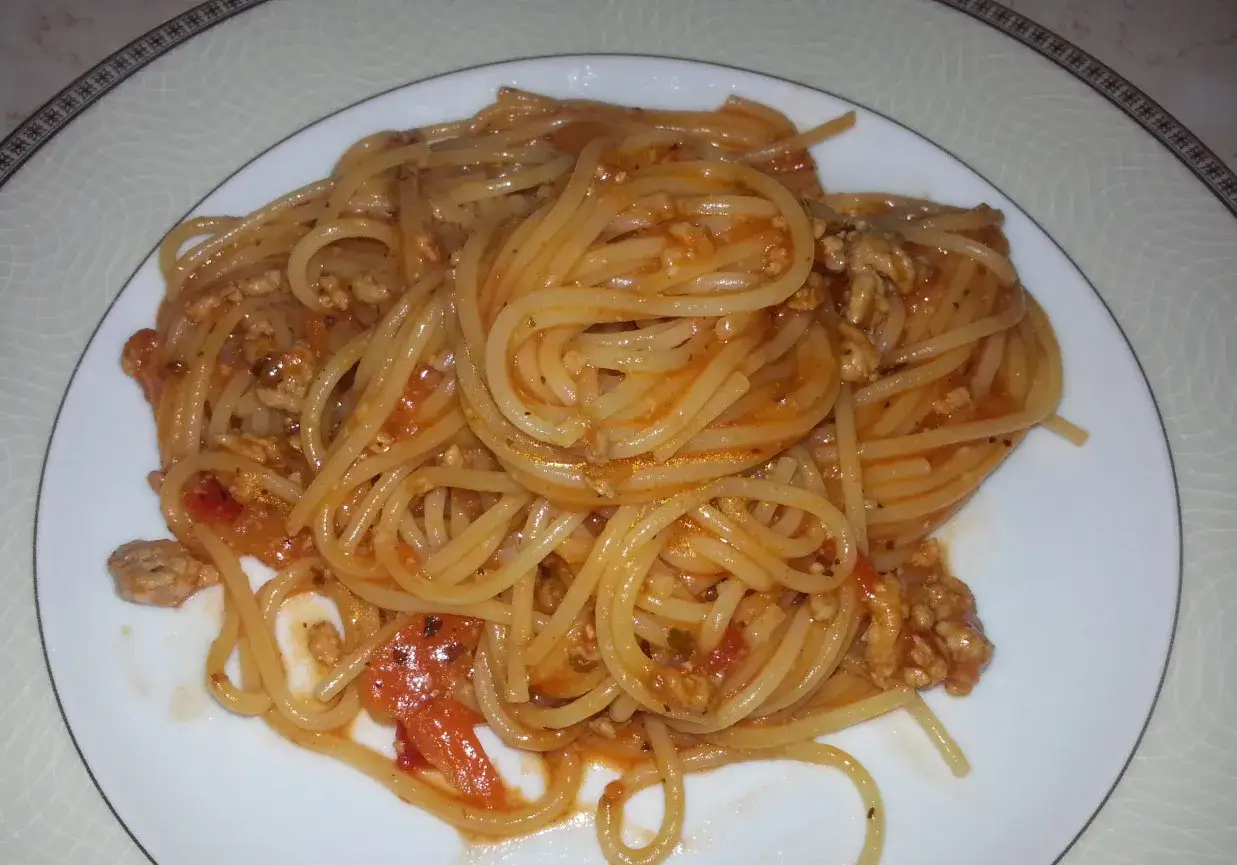 Spaghetti bolognese z passatą, aromatyczny sos mięsny z pomidorami i mielonym mięsem, podany na białym talerzu.