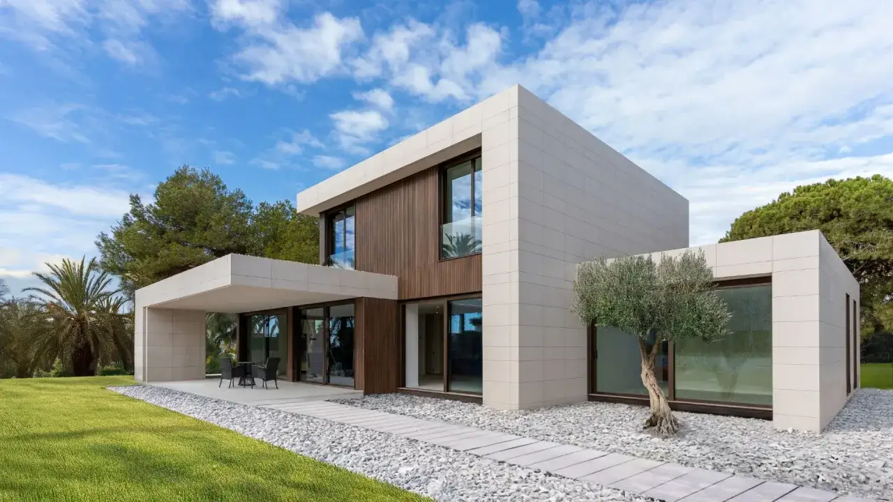 Moderna casa prefabricada dise&ntilde;o minimalista con revestimiento de piedra y madera, rodeada de c&eacute;sped y olivo.