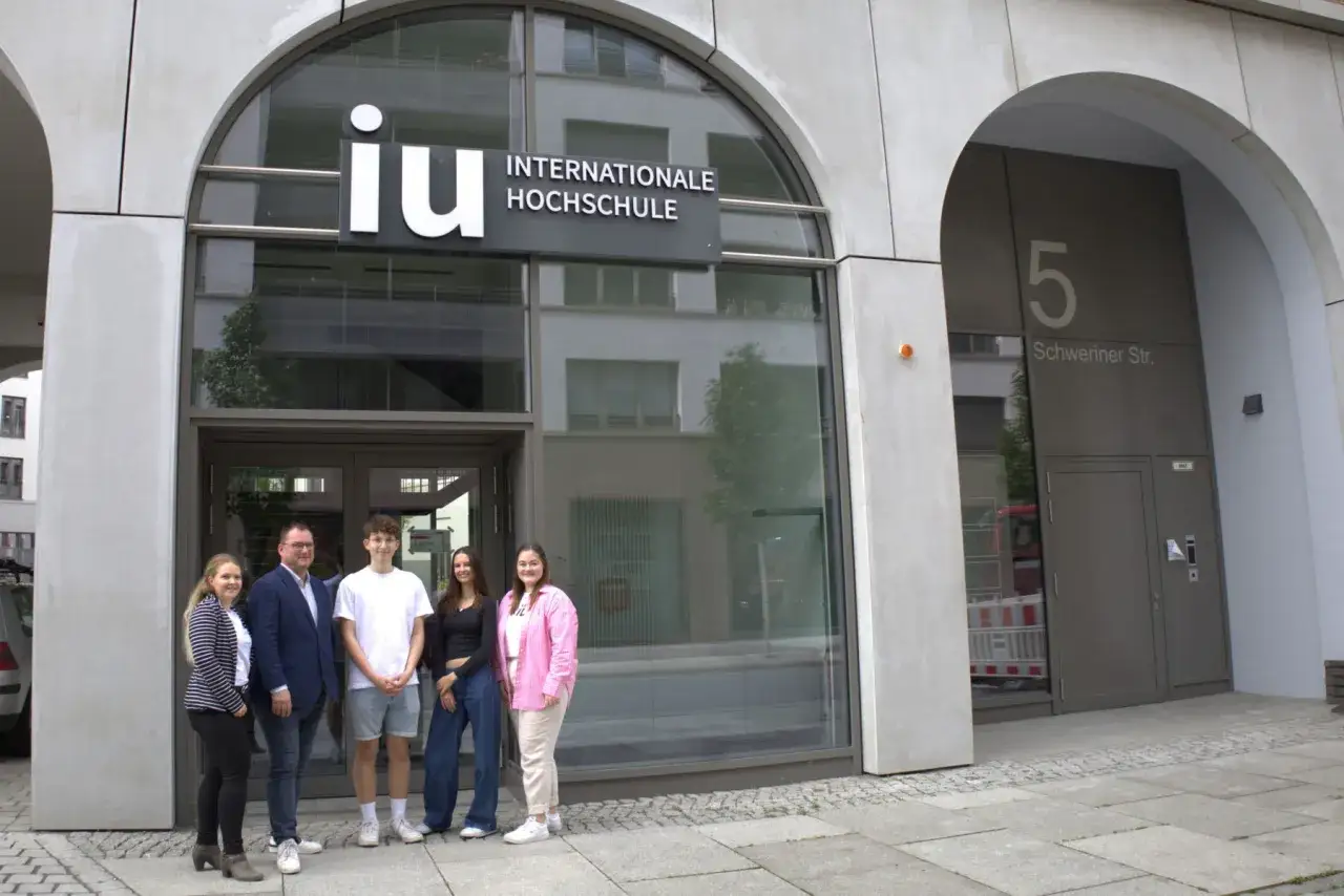 F&uuml;nf Personen vor der IU Internationale Hochschule. Ein Mann und vier junge Leute, bereit f&uuml;r ihren **iu studienstart**.