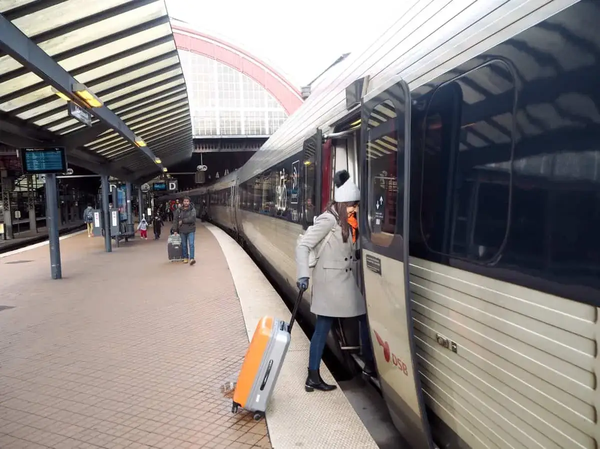 Resa med t&aring;g K&ouml;penhamn Hamburg med DSB. En kvinna med resv&auml;ska stiger p&aring; ett t&aring;g.