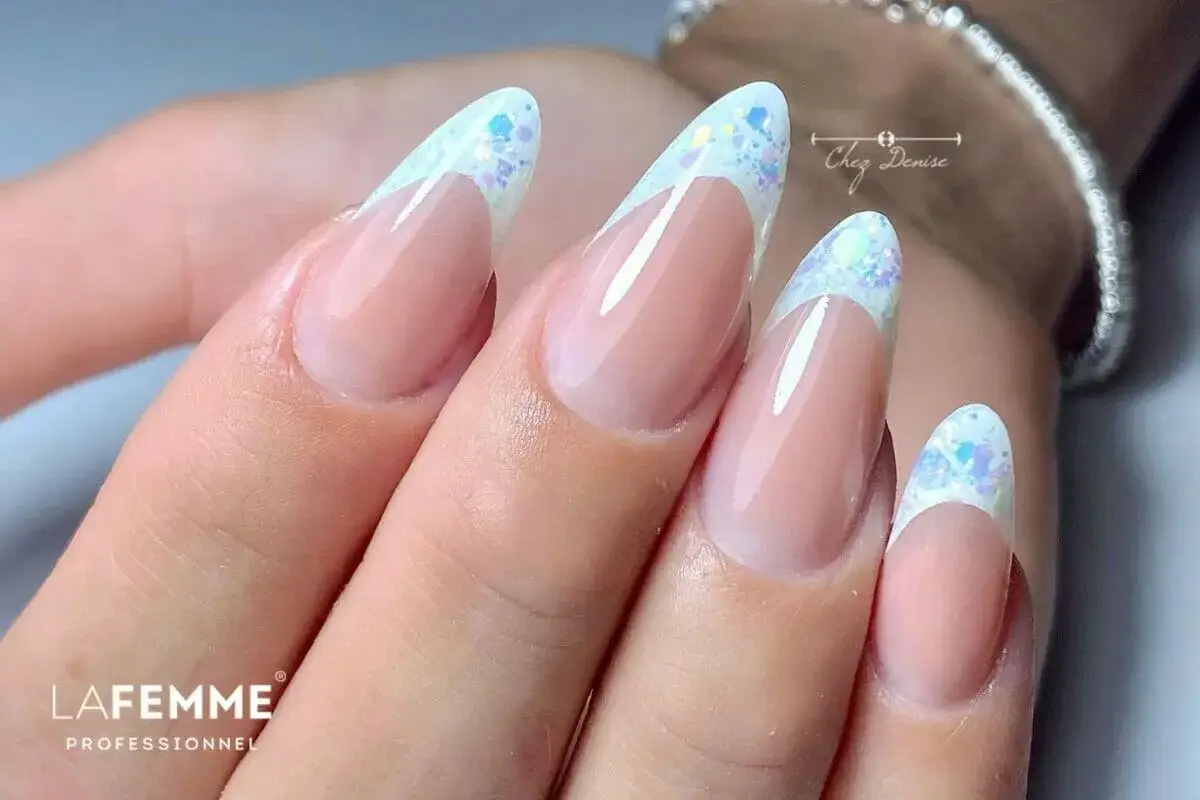 Unghie french con disegni scintillanti e glitter, un look elegante e festoso per le tue mani.