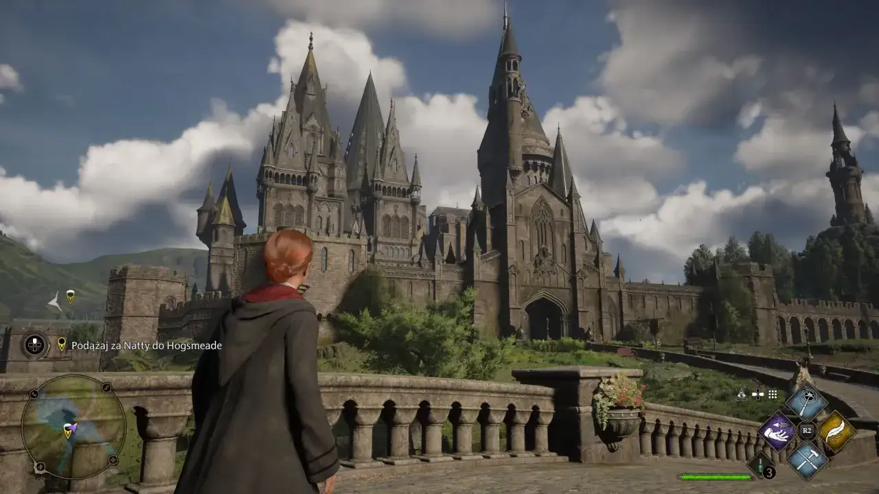 Postać w szacie patrzy na Hogwart. W tej hogwarts legacy recenzja zobaczysz, jak wspaniała jest ta gra.