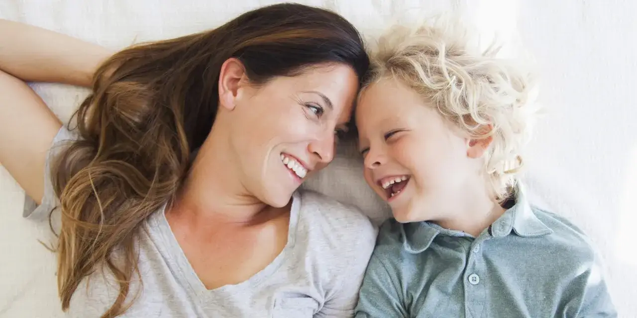 Madre e figlio ridono insieme, un momento di gioia che contrasta la paura di morire e lasciare i figli.