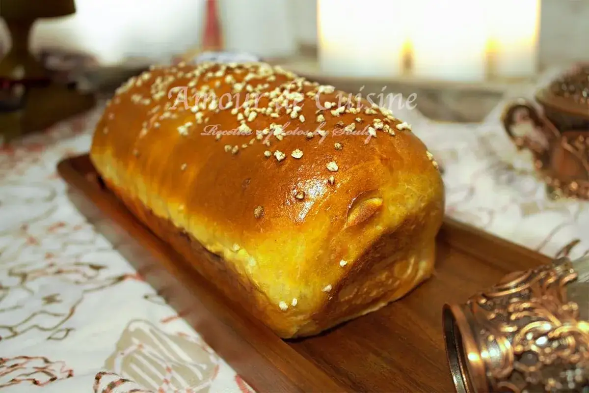 Un pain brioché salé doré, parsemé de graines, prêt à être dégusté. Une recette gourmande pour tous les moments.
