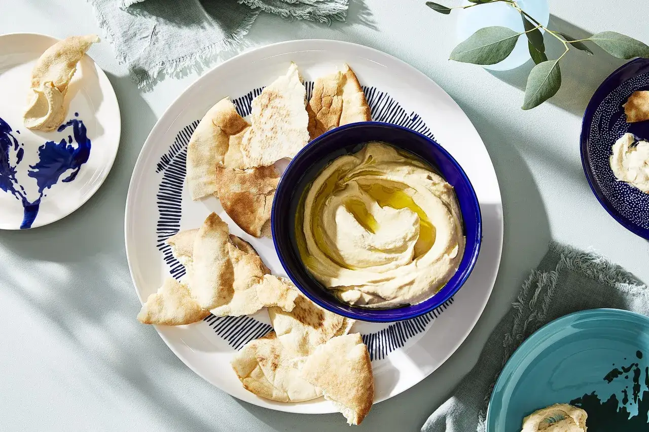 Hummus z oliwą i pitą na talerzu. Szukasz, czym zastąpić tahini? Oto inspiracja!