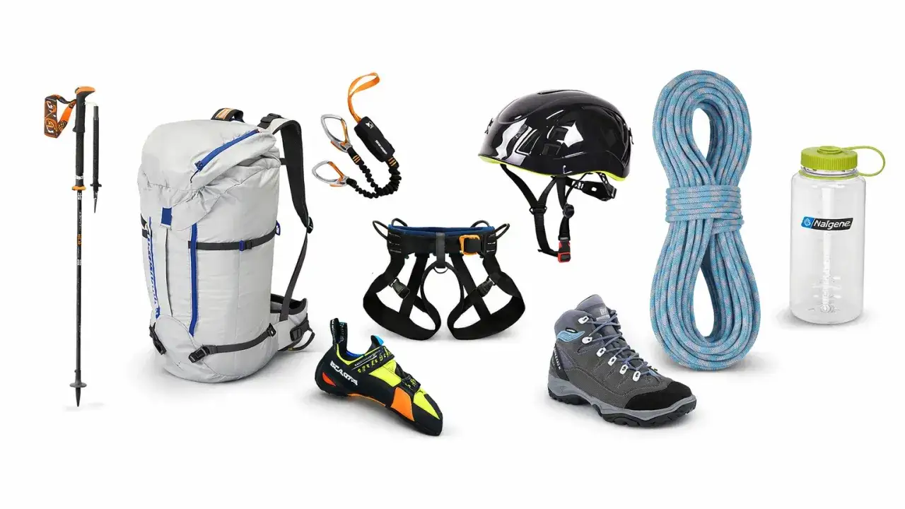 Attrezzatura completa per escursioni in montagna: zaino, casco, imbracatura, corda, scarponi, bastoncini e borraccia.