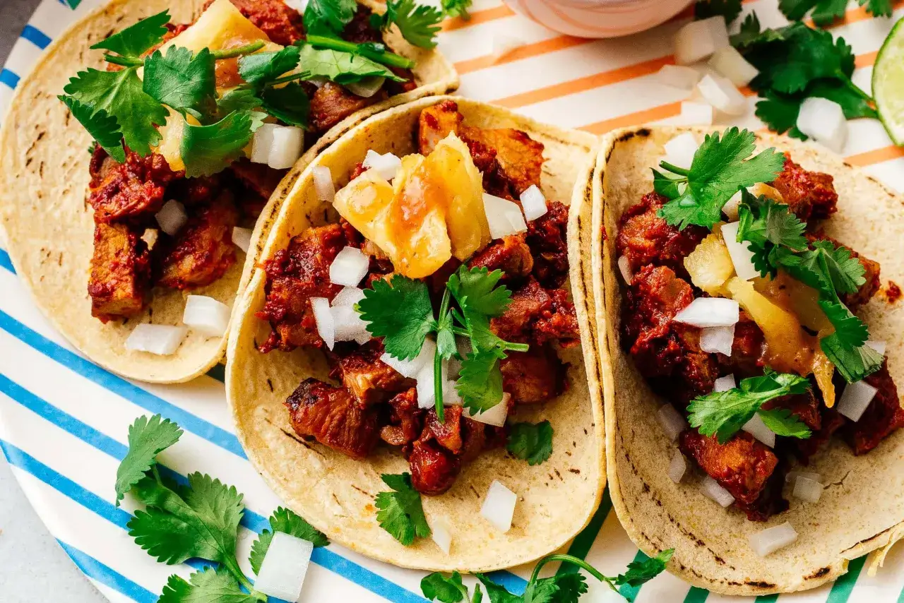 Tre tacos al pastor med saftigt fläsk, ananas, lök och koriander. En klassisk mexikansk rätt som är svår att motstå.