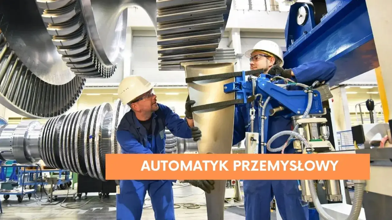 Dwóch pracowników w kaskach i niebieskich kombinezonach pracuje przy wielkiej turbinie. To praca dla automatyka przemysłowego.