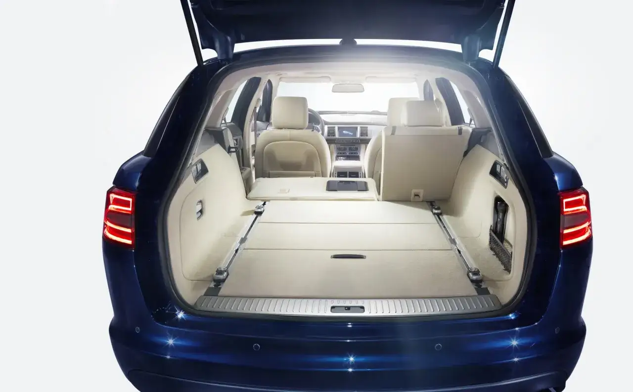 Jaguar XF 3.0 diesel z otwartym bagażnikiem, ukazujący przestronne wnętrze i jasne, beżowe siedzenia. Idealny na rodzinne wyjazdy.