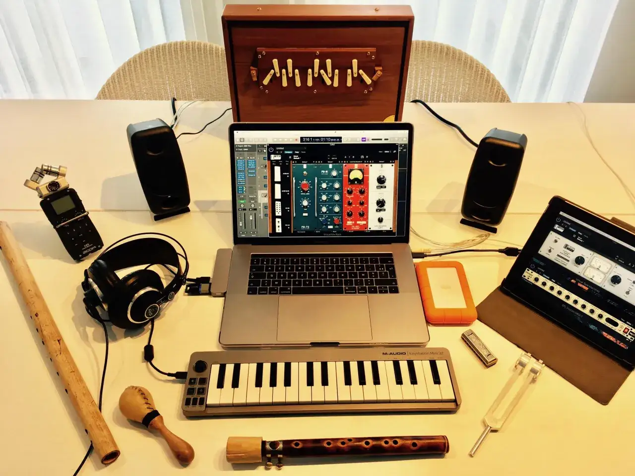 Musikproduktion mit Laptop, Lautsprechern, Kopfh&ouml;rern, Mini-Keyboard und einem Tascam X8-Rekorder.