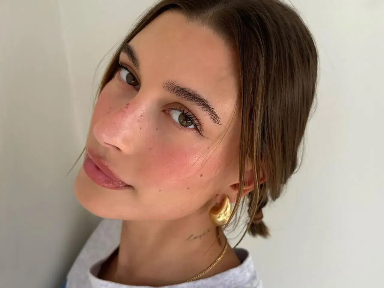 Rostro con pecas y rubor rosado, labios brillantes y un toque de strawberry makeup.