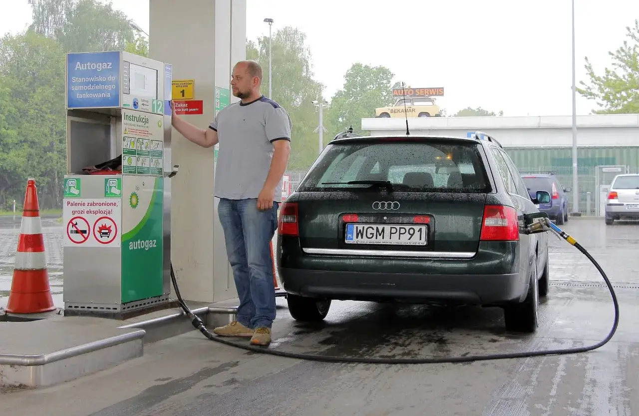 Mężczyzna tankuje autogaz do Audi. Sprawdza, ile kosztuje gaz do auta, by zaoszczędzić na podróży.
