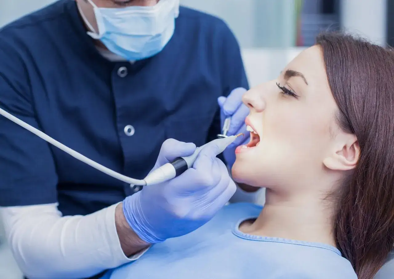 Dentysta wykonuje zabieg znieczulenia śródwięzadłowego u pacjentki.