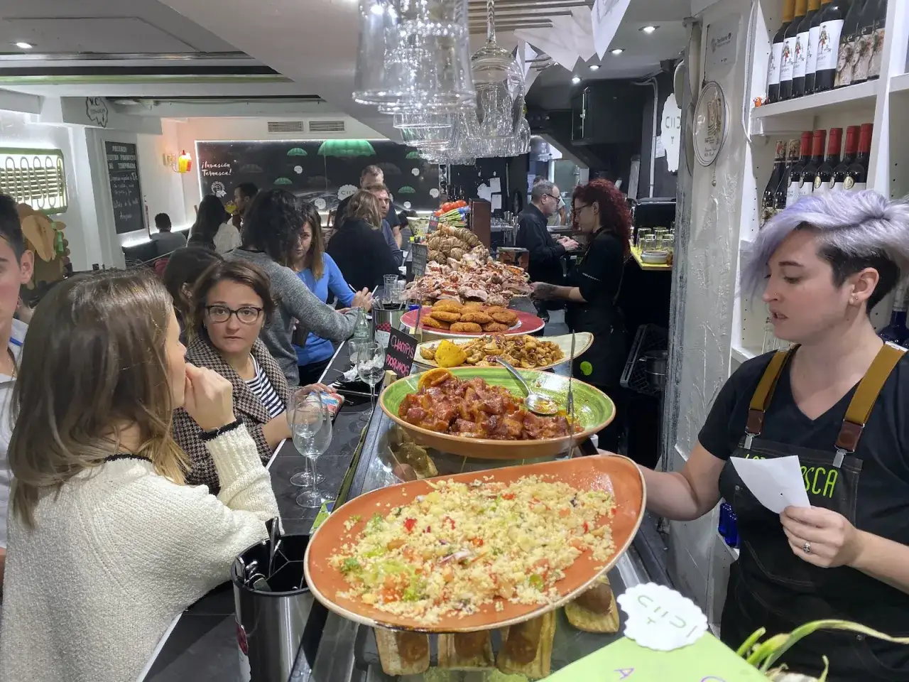 Gente disfrutando de tapas y comida en un bar, una excelente opción de donde comer en Zaragoza.