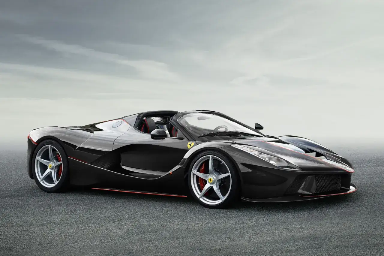 Czarny Ferrari Spider z czerwonymi akcentami, gotowy do jazdy po torze.