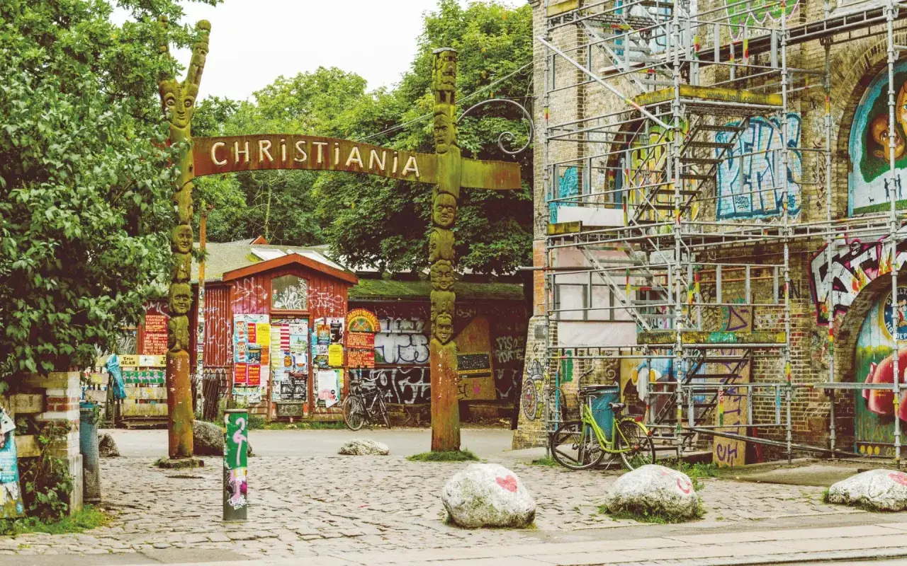 Brama do Christianii, jednego z nietypowych miejsc w Kopenhadze, z rzeźbionym słupem i graffiti.