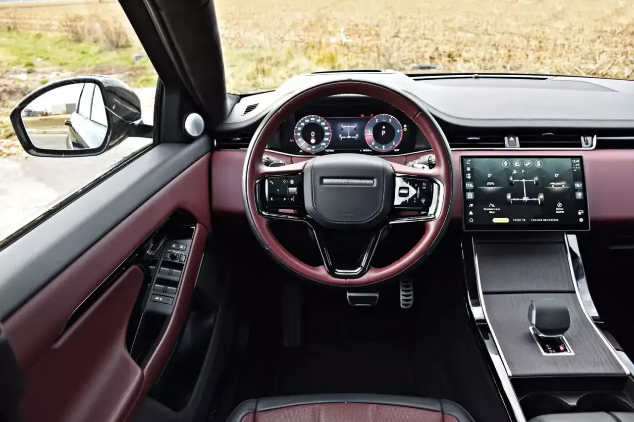 Wnętrze Land Rover Evoque z bordową skórą i nowoczesnym panelem dotykowym.