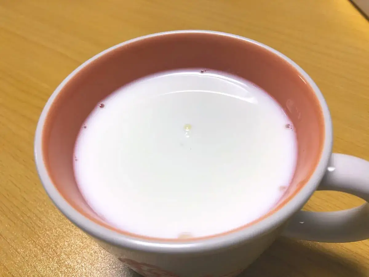 Tasse de lait chaud, une fine peau de lait se forme à la surface, prête à être dégustée.