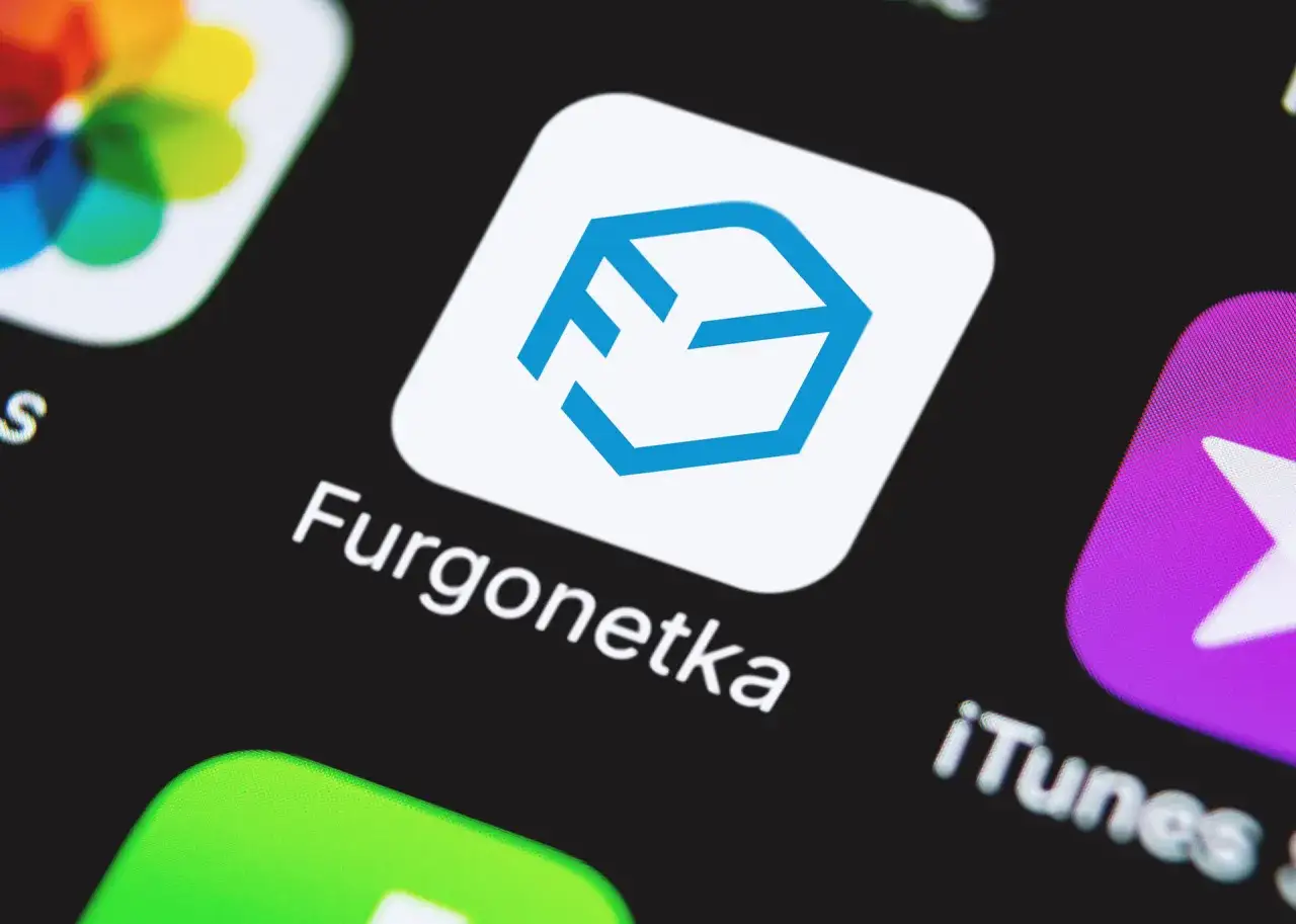 Ikona aplikacji Furgonetka z niebieskim logo w kształcie sześcianu. Szybka dostawa na wyciągnięcie ręki.