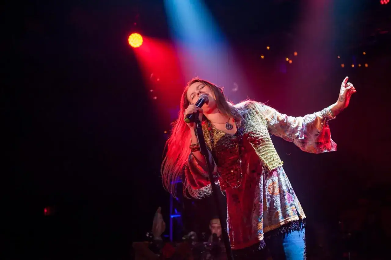 Wokalistka na scenie, przypominająca Janis Joplin, wykonuje swoje utwory.