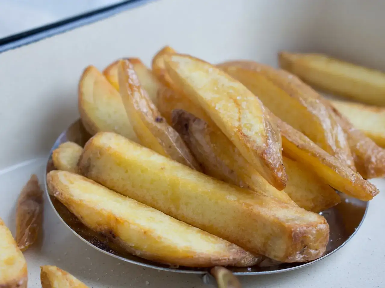 Goldbraune, knusprige Kartoffelspalten, frisch zubereitet. So gelingen Pommes selbst machen perfekt!