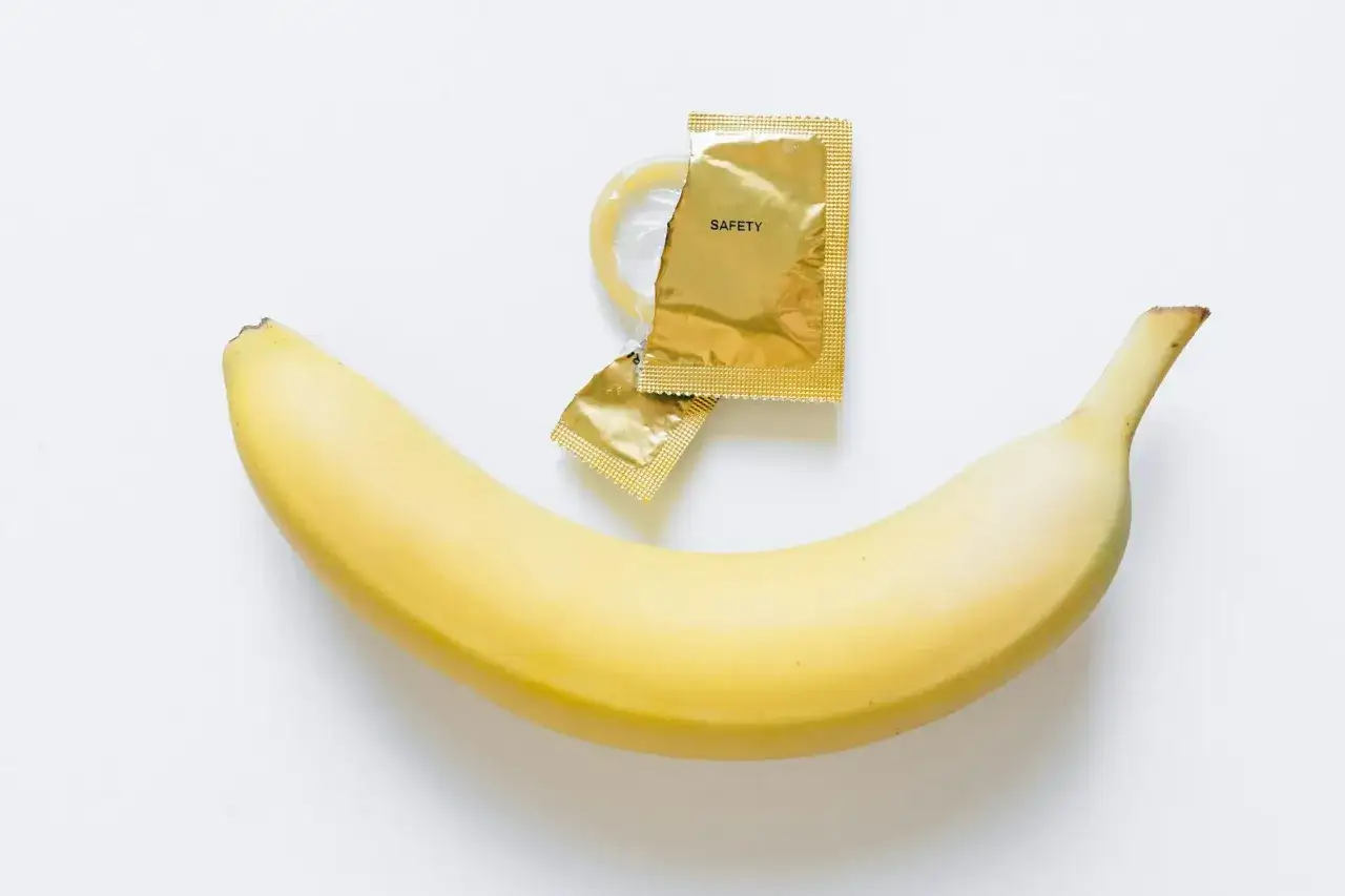 Banan i prezerwatywa w złotym opakowaniu z napisem 