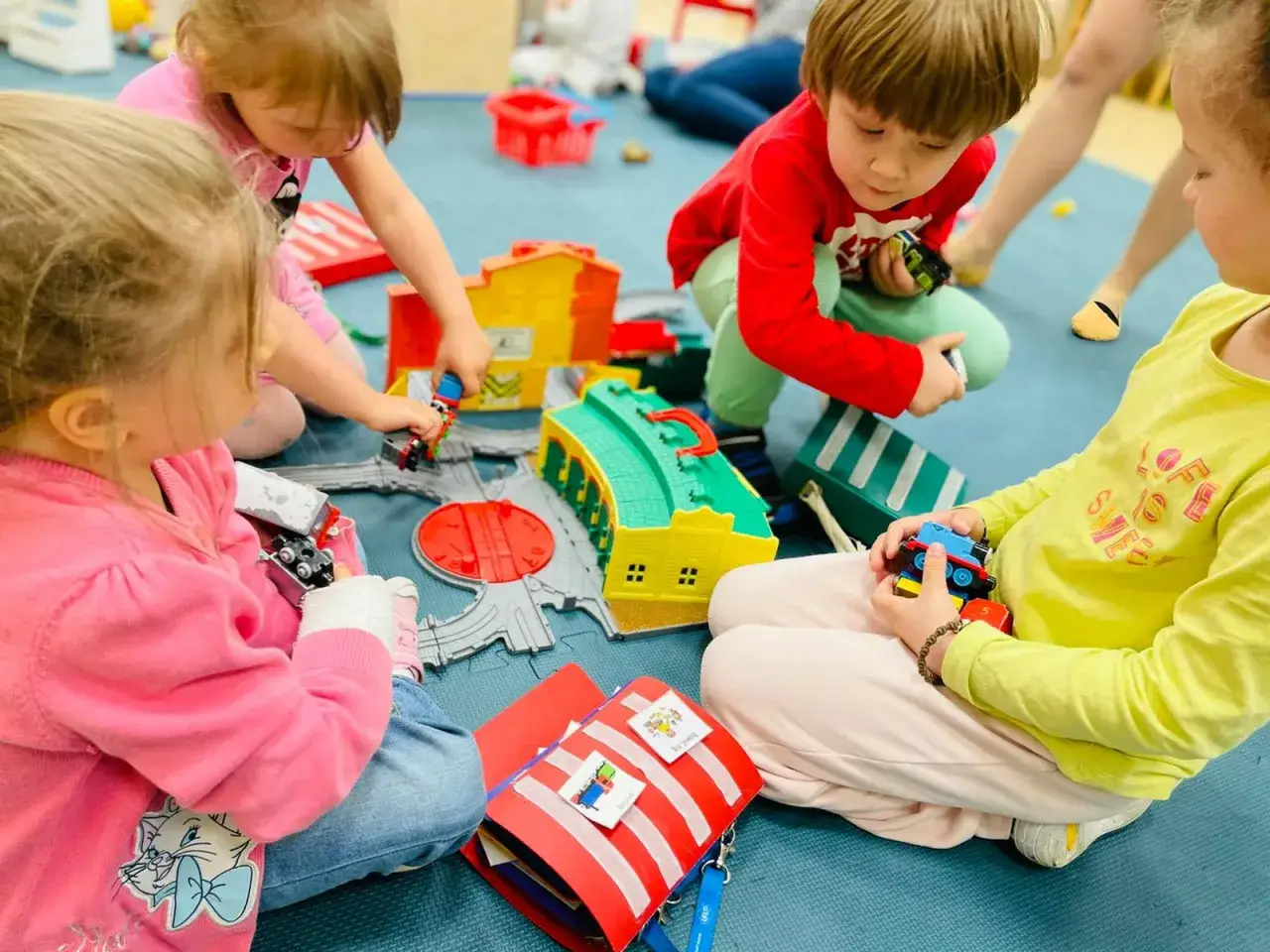 Dzieci bawią się pociągami. W przedszkolu jest wielu opiekunów, więc ile dzieci przypada na jednego opiekuna w przedszkolu?
