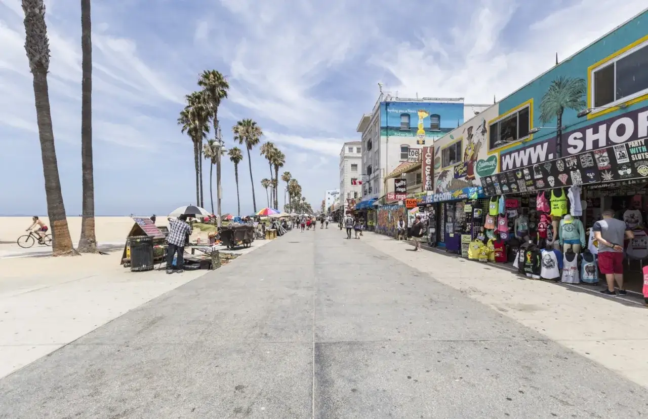 Spacerem po słonecznym Venice Beach, z palmami, sklepikami z pamiątkami i ludźmi cieszącymi się dniem.