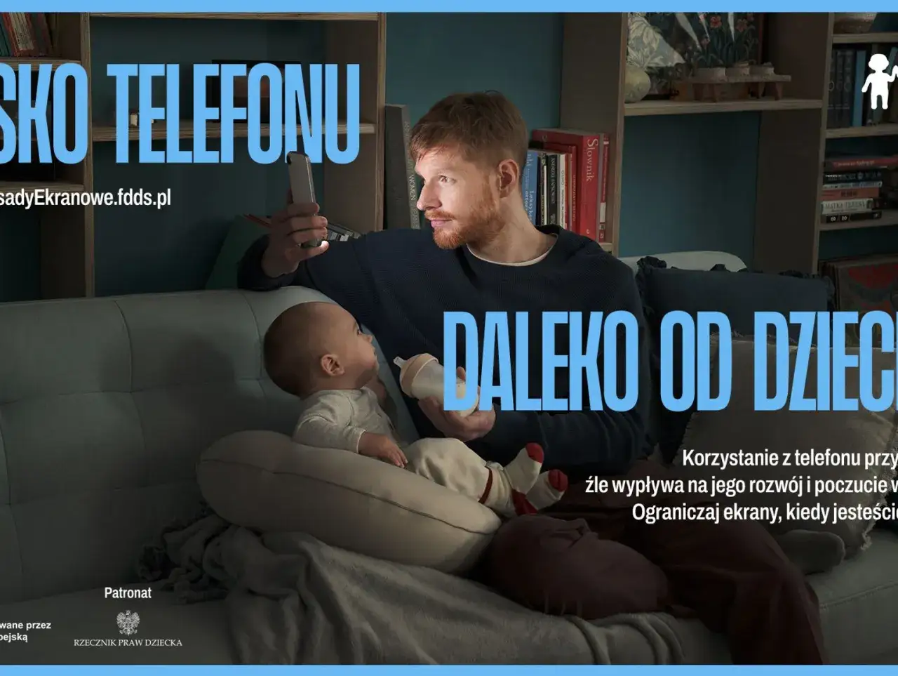 Ojciec z telefonem obok niemowlaka. Jak odzwyczaić dziecko od telefonu? Ograniczaj ekrany, kiedy jesteś z dzieckiem.