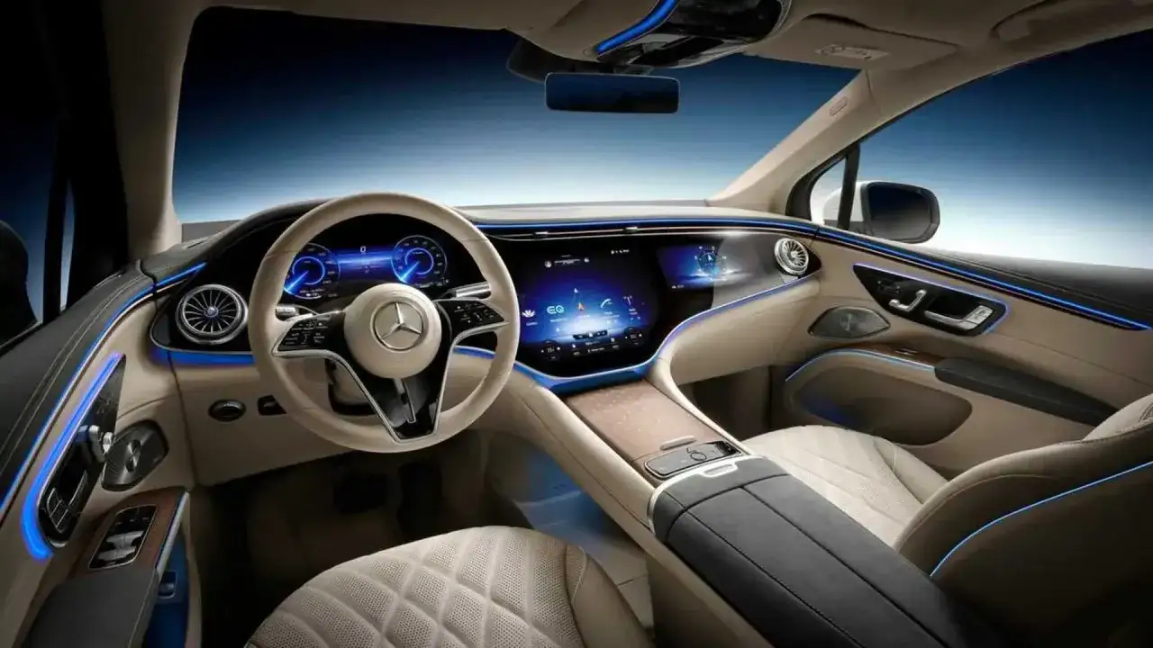 Interior futurista del glc el&eacute;ctrico 2026 con pantallas digitales, iluminaci&oacute;n ambiental azul y asientos de cuero beige.