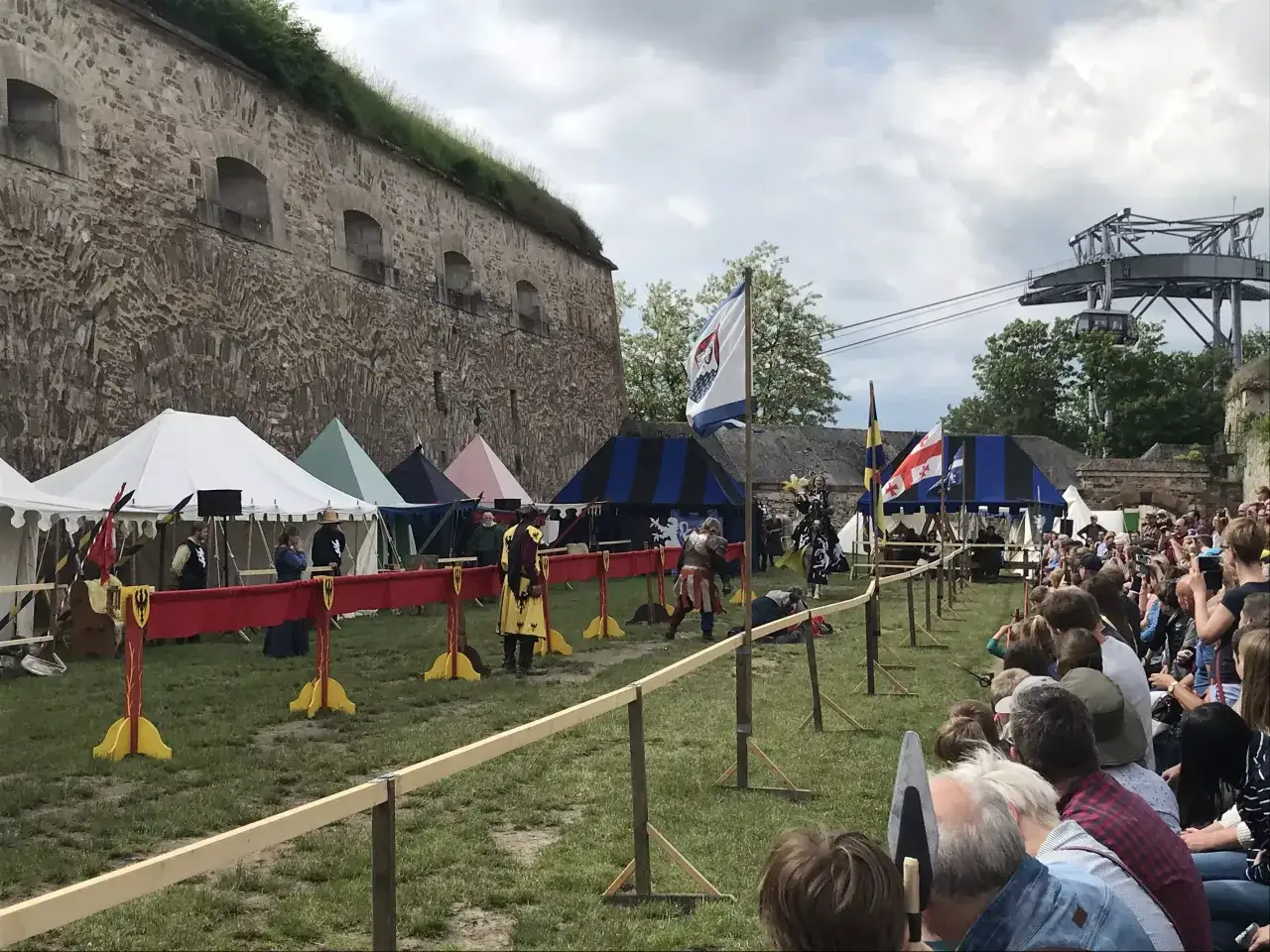 Ritterk&auml;mpfe vor der Festung Ehrenbreitstein. Ein mittelalterliches Spektakel mit Zelten und Zuschauern, das an einen lebendigen **Festung Ehrenbreitstein Spielplatz** erinnert.
