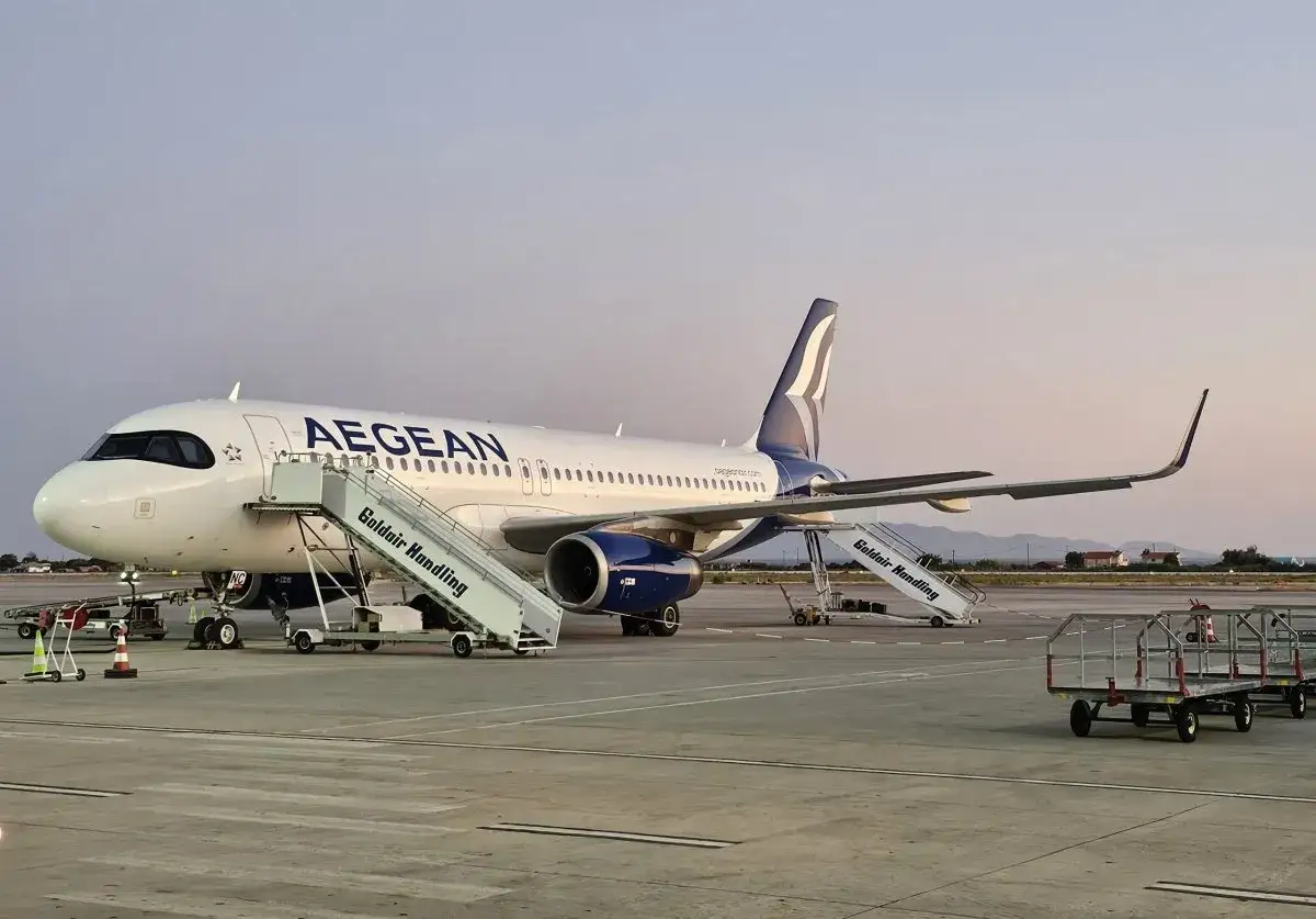 Ett Aegean Airlines-plan står på marken med trappor på plats. Perfekt för din handbagage-resa.