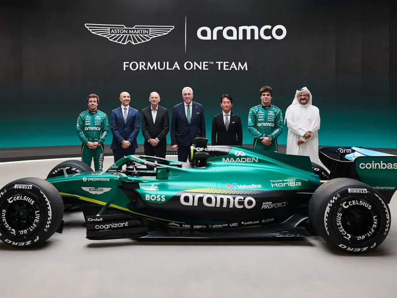 El equipo Aston Martin Aramco Cognizant Formula One Team posa junto a su coche verde brillante.