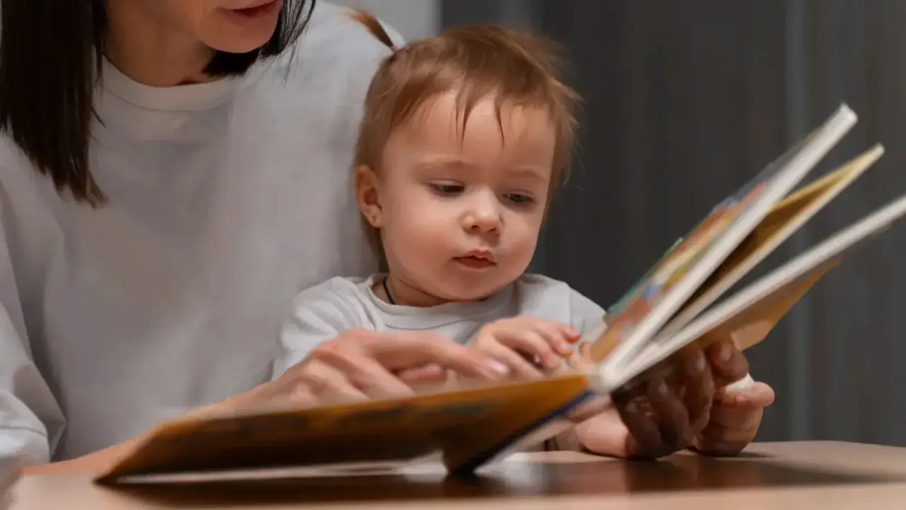 Bambina con mamma sfoglia un libro, forse &egrave; il momento in cui inizia la lallazione.