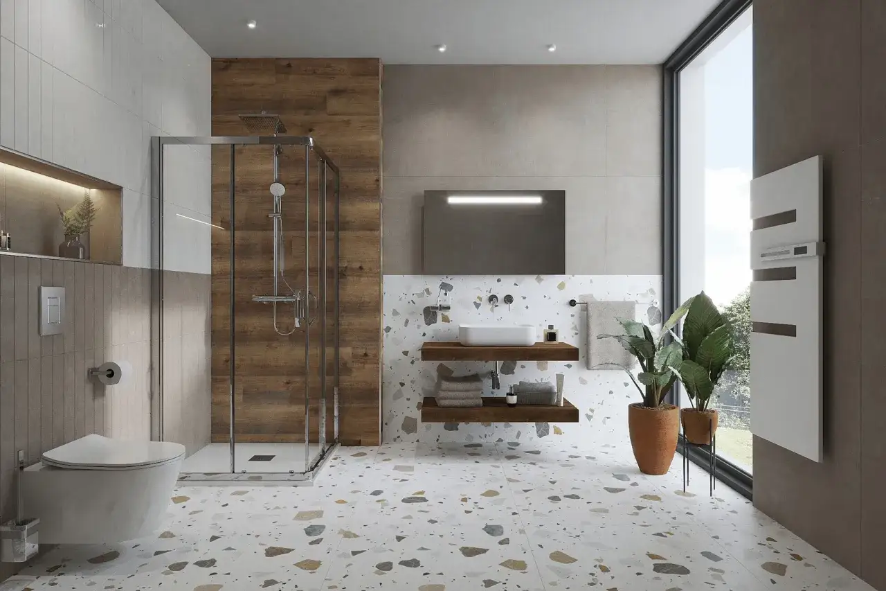 Une **salle de bain minimaliste** avec douche vitrée, lavabo suspendu, et sol en terrazzo coloré. L'ambiance est épurée et moderne.