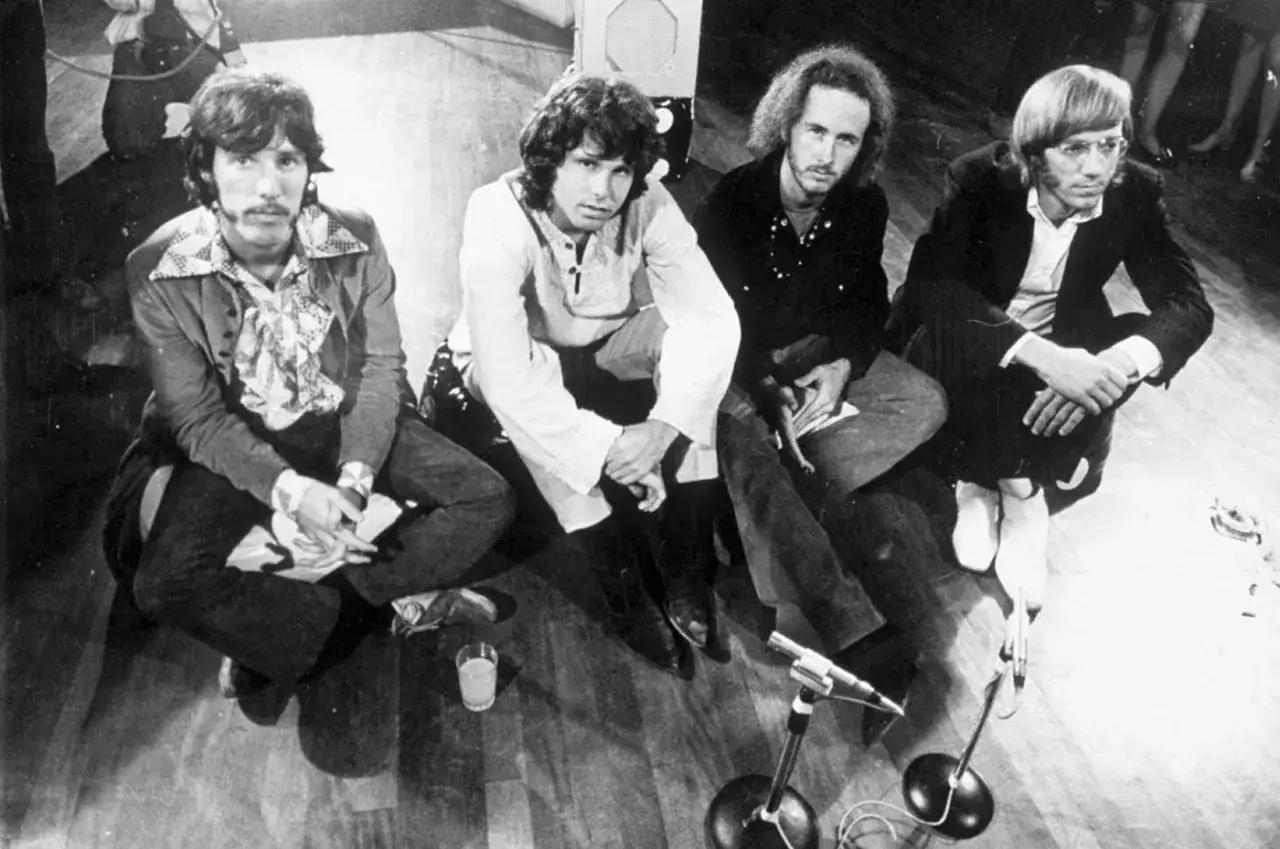 Czterech członków The Doors siedzi na podłodze, gotowych do występu.