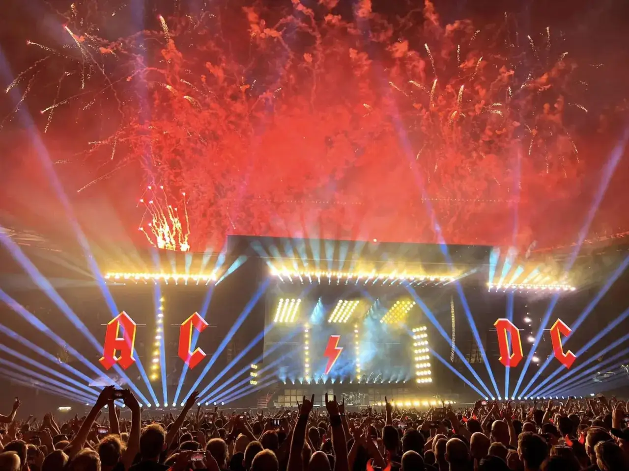 Niesamowite **AC/DC koncerty** z pirotechniką i tłumem w ekstazie. Wielkie logo zespołu rozświetla scenę, a fajerwerki tworzą czerwony spektakl na niebie.