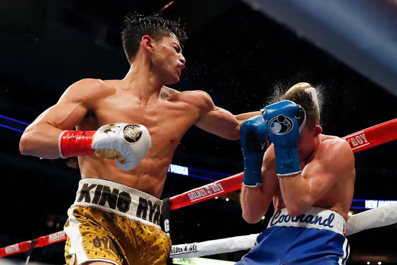 A boxer lands a powerful left hook, his opponent recoiling from the impact in a dramatic boxing match.