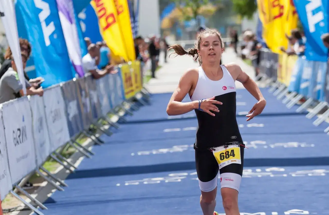 Zawodniczka z numerem 684 biegnie na trasie 1/8 ironman, walcząc o każdy metr.